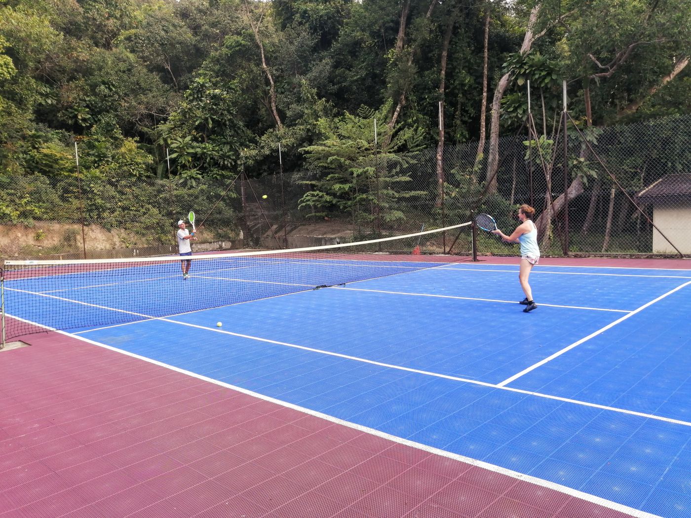 Couple playing tennis on the property court